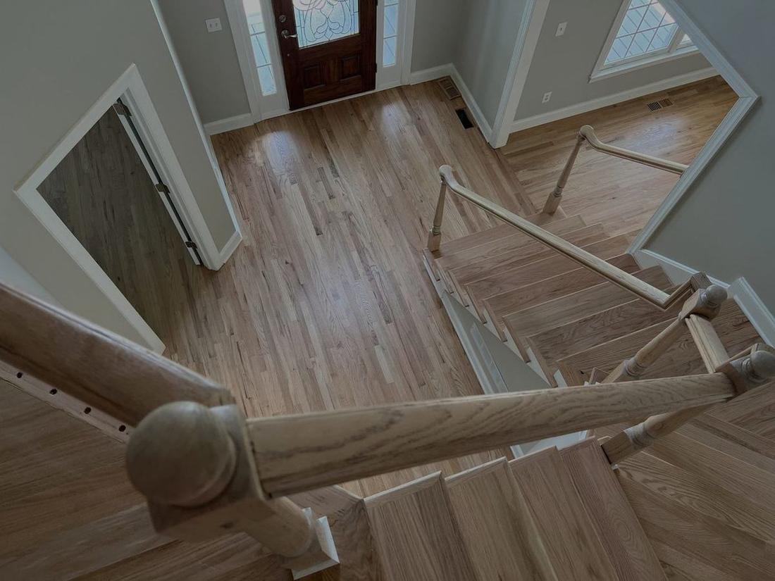 Refinished hardwood staircase overlooking the foyer in a Canton, GA home