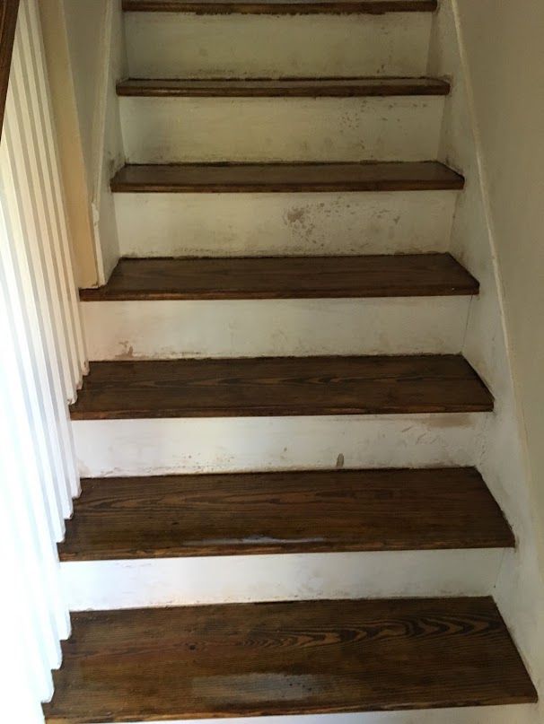 Stain marks along the risers and stringers up a full staircase — a painter touches these up after our work.