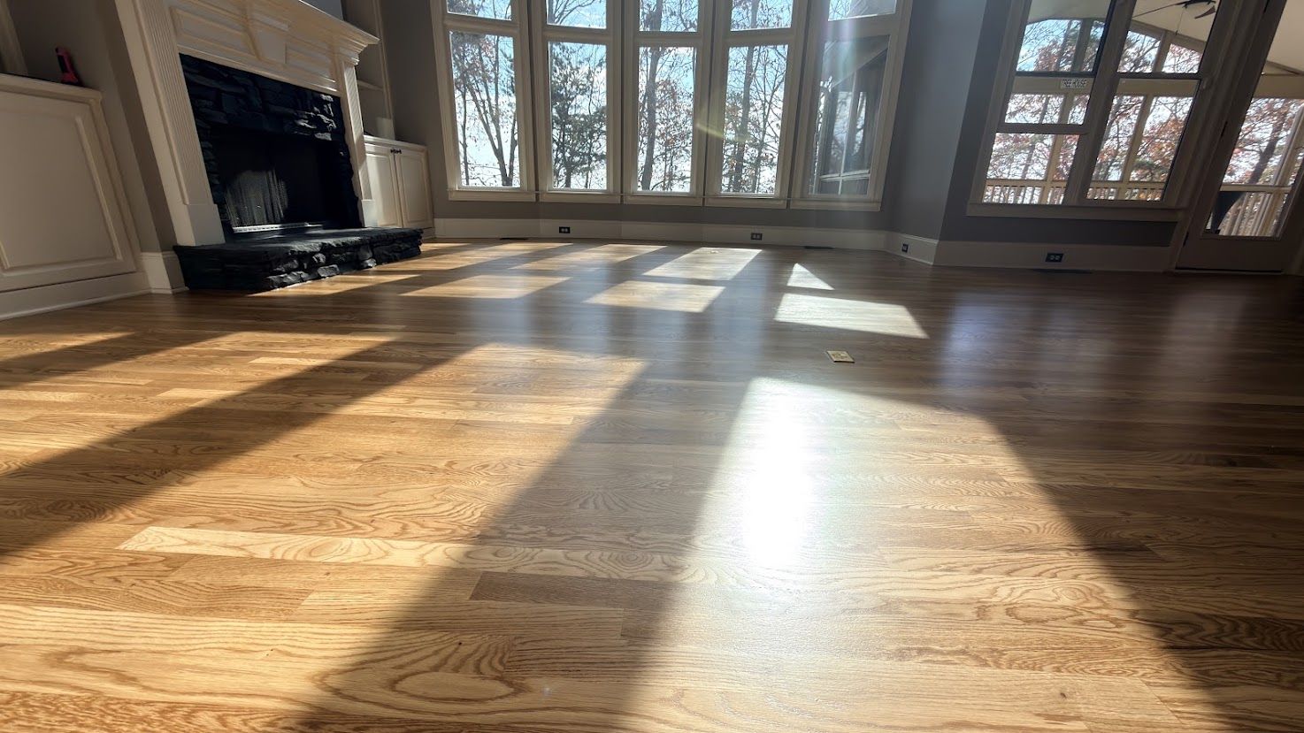 Sunlit great room with red oak hardwood floors finished in Fruitwood, refinished by The Hardwood Guys