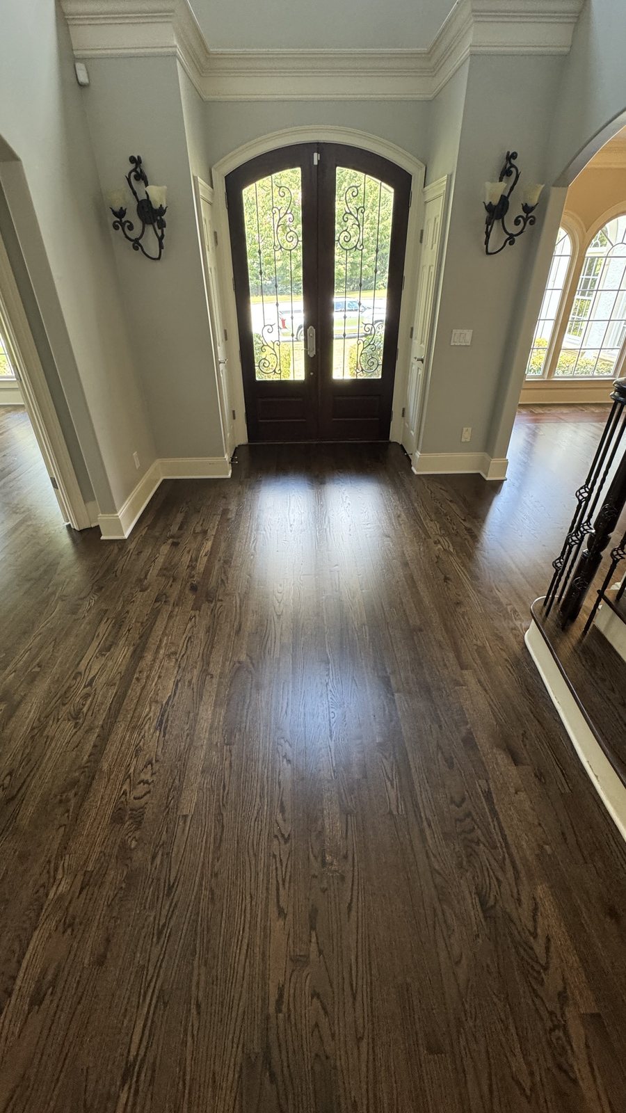 Foyer with red oak hardwood floor in Dark Walnut stain and matte finish, arched double front door with wrought-iron glass inserts