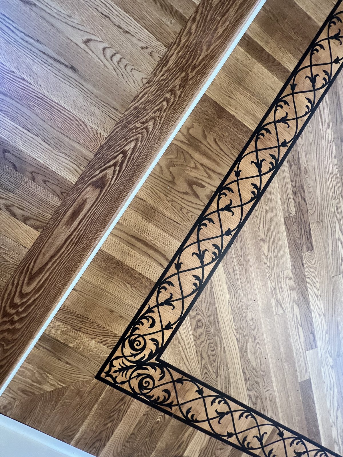 Corner detail of a decorative inlay border in a red oak hardwood floor, Golden Oak stain with matte finish