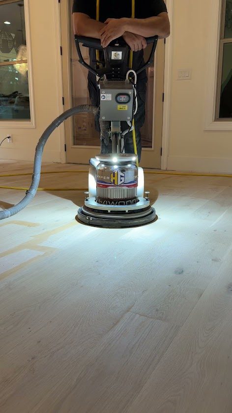 Planetary sander with dust extraction resurfacing a white oak floor in a North Metro Atlanta home