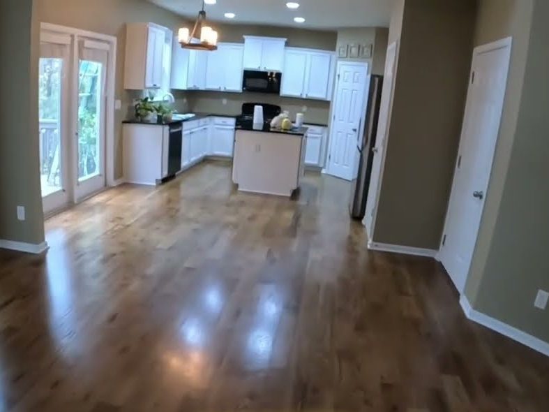 Stained hardwood floor running into an open kitchen, hardwood installation and refinishing in Woodstock, GA